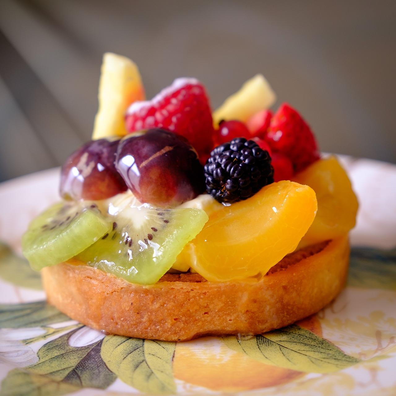 Crostata di frutta con frolla dorata e croccante, decorata con frutta fresca colorata.