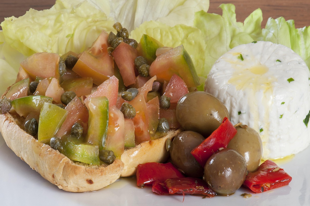 Caponata siciliana servita in un piatto, con melanzane, pomodori e olive.