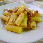 Pasta all'amatriciana servita con guanciale e pomodoro, tipica della cucina romana.