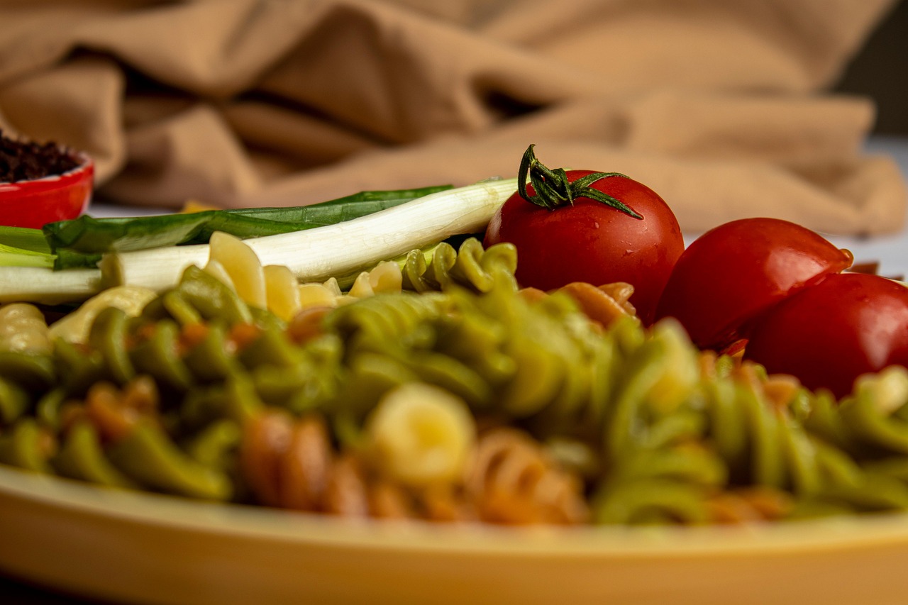 Pasta al pomodoro con olio versato a fine cottura, piatto appetitoso e colorato.