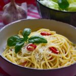 Piatto di spaghetti aglio e olio, con aglio dorato e prezzemolo fresco, pronto per essere gustato.