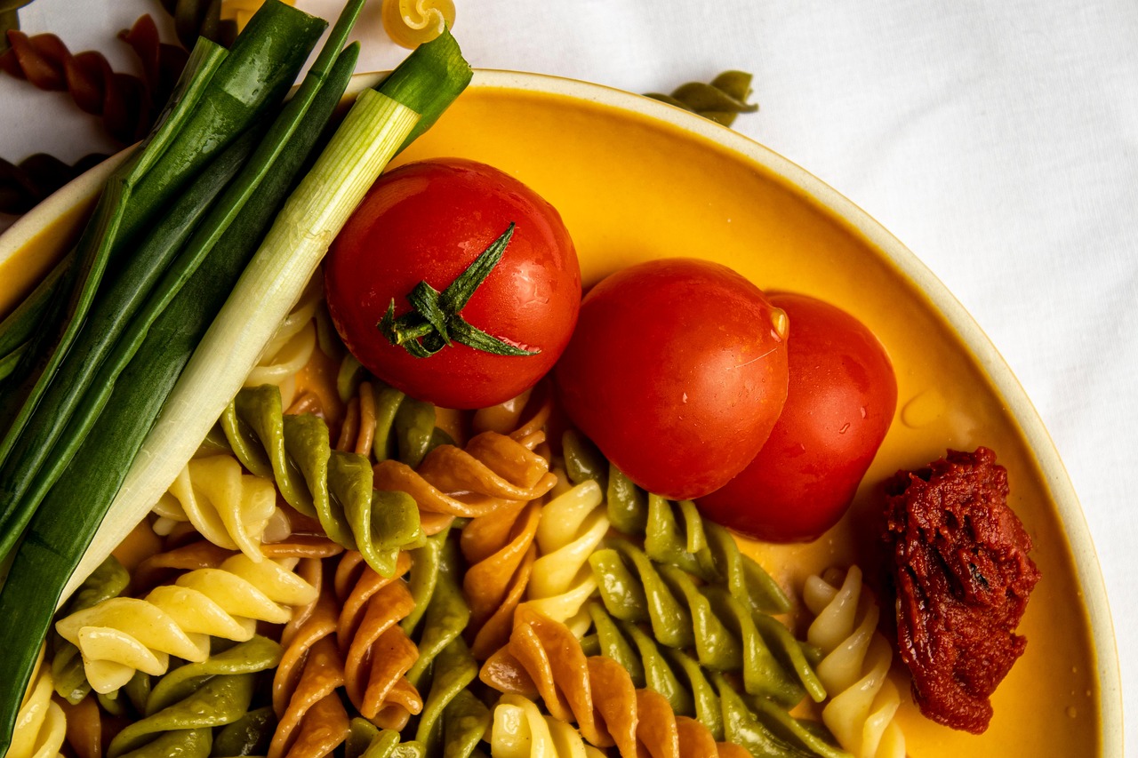 Pasta al pomodoro con olio versato, evidenziando il momento di aggiunta durante la preparazione.