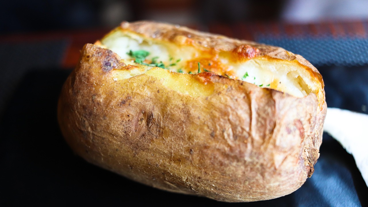 Patate al forno dorate con crosticina croccante e morbidezza interna, pronte per essere servite.