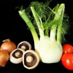 Lenticchie e finocchi freschi su un tagliere, simbolo di una cucina sana e digestiva.