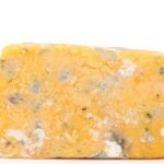 Formaggio grasso su un piatto, simbolo del colesterolo alto da evitare.