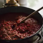 Pentola grande di sugo appena cotto: perché dividerlo in contenitori bassi aiuta a raffreddarlo più rapidamente